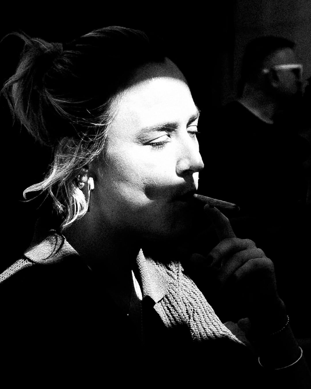 A woman smoking in hard light